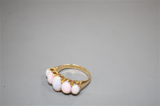 An Edwardian 18ct gold and graduated five stone white opal half hoop ring, size Q, gross 5.5 grams.